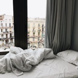 Modern bedroom interior showcasing a scenic view of Barcelona, Spain.