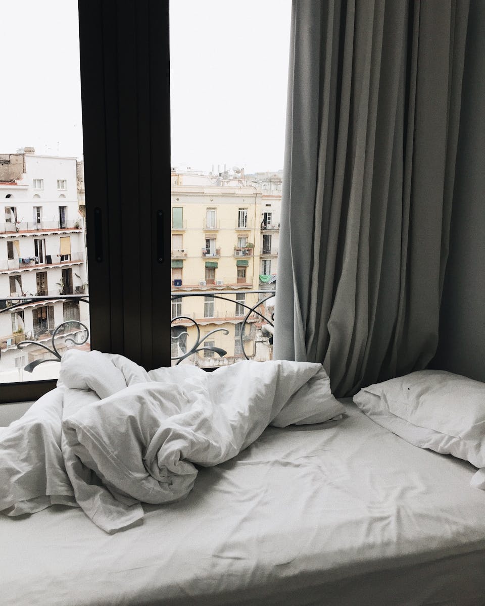 Modern bedroom interior showcasing a scenic view of Barcelona, Spain.