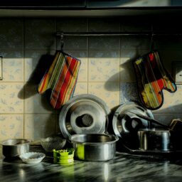 Kitchen pots and pans with oven mitts.