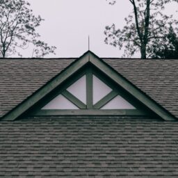 a roof with a triangle shaped window on top of it